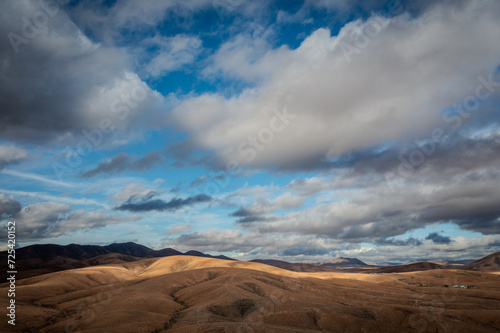 aerial view of a desert landscape on fuerteventura with a cloudy blue sky