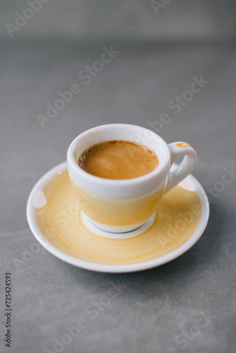 Close up of a cup of espresso or dopio on a gray stone background.