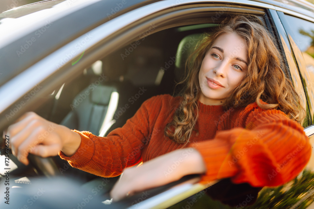 Beautiful woman sitting in car and looking through the window. Car travel, lifestyle, carshering concept. Beautiful woman sitting in car and looking through the window. Car travel, lifestyle, carshering concept.