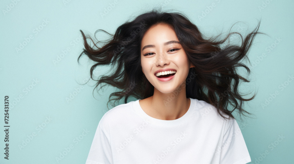 Fototapeta premium Young happy smiling Asian woman model wearing tshirt looking at camera on color background. Face skin hair care korean cosmetic and makeup, fashion ads. Beauty portrait. White t-shirt mock up template