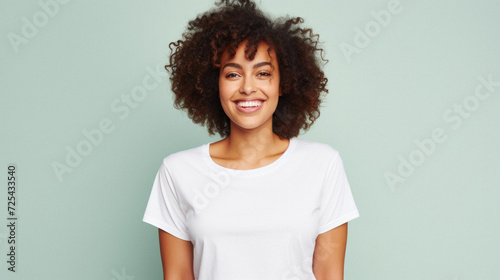 Young happy smiling African American woman model wearing tshirt standing on color background. Face skin hair care cosmetics makeup, fashion ads. Beauty portrait. White t-shirt mock up template .