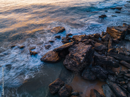 Pretty blue sunrise at the beach with calm seas © Merrillie