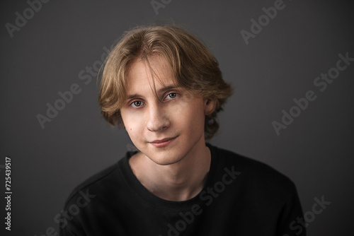 Portrait of a handsome young guy on a black background - happy face.