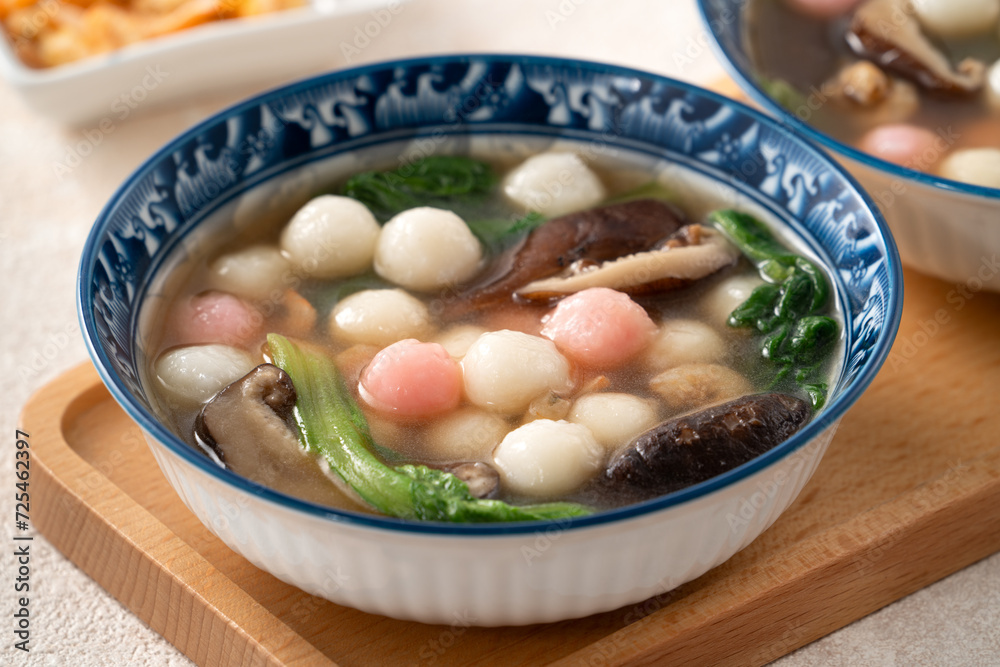Eating red and white small tangyuan with savory soup and vegetable. Eating red and white small tangyuan with savory soup and vegetable.