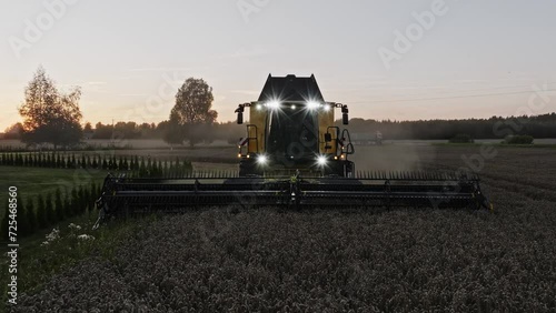 Combine harvester working in the field in the beatiful sunset