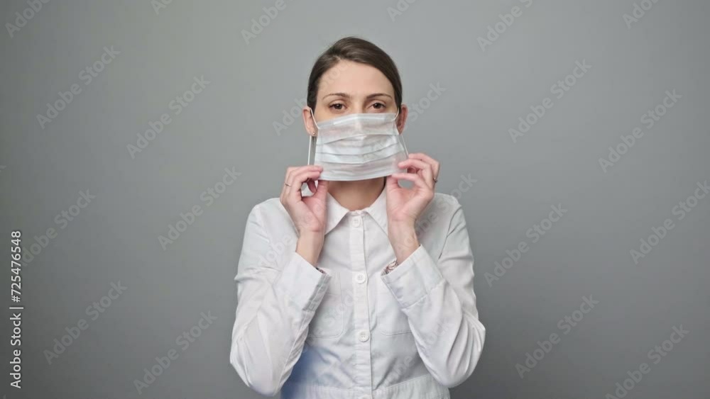 Portrait of a female doctor or nurse looking at the camera on grey background