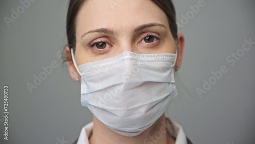 Portrait of a female doctor or nurse looking at the camera on grey background photo