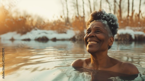 Smiling middle-aged black woman in a winter cold pond photo