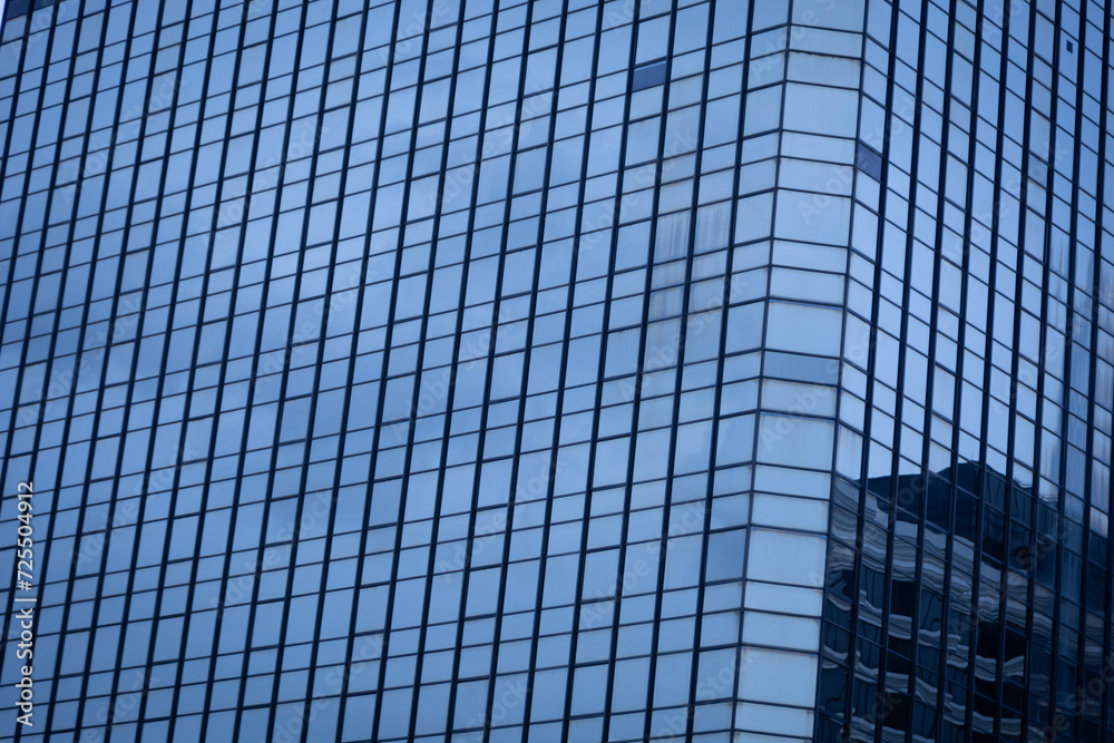 The modern building in the business district has glass windows to let in the light. The modern building in the business district has glass windows to let in the light.