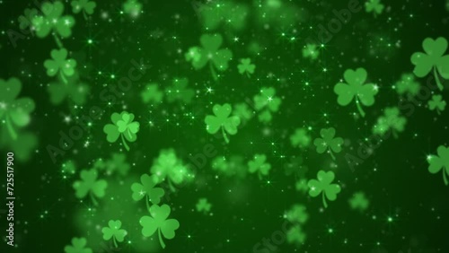 Lucky shamrocks, shiny stars and glowing glittering particles on a dark green gradient background. This Saint Patrick's Day celebration party background animation is full HD and a seamless loop.