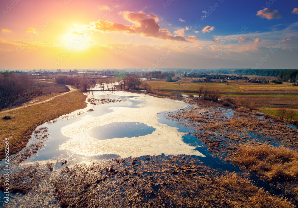 Φωτογραφία Aerial view of the countryside and frozen winding brook in the evening at sunset light