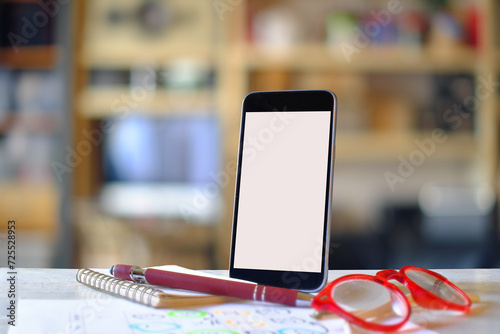 mobile phone on blurred office bookshelf with copy space, white blank screen for text, mobile app design and advertising, online marketing