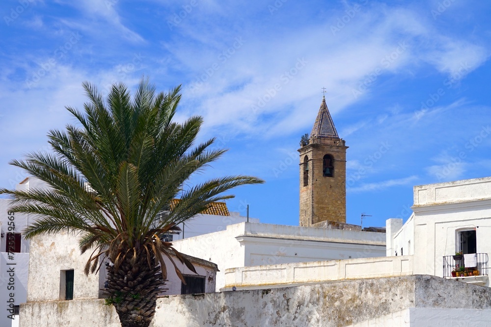 tower of the church Iglesia Divino Salvador looking over the roofs of the white Andalusian houses in Vejer de la Frontera, Costa de la Luz, Spain