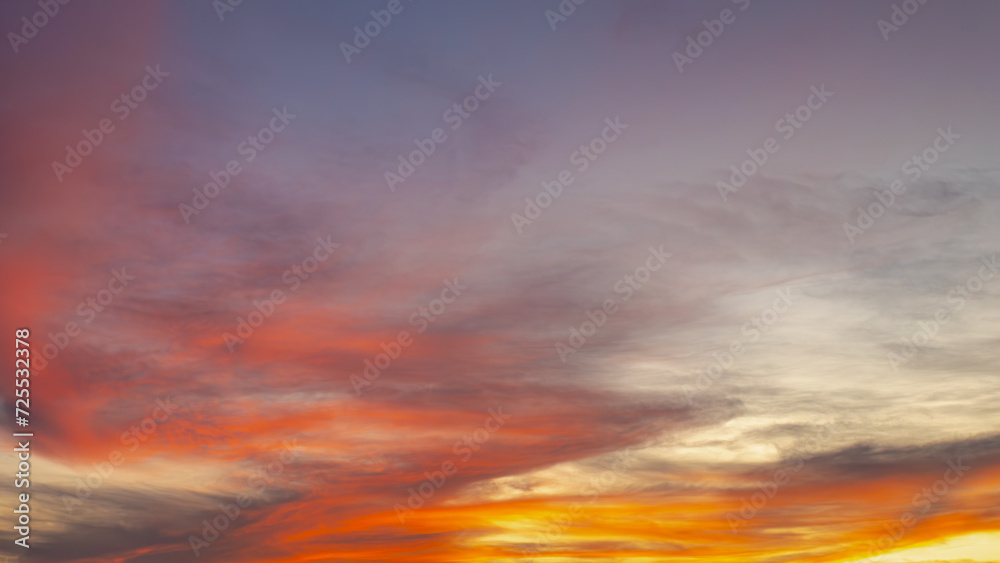 Sunset sky background with colourful golden yellow skies in the evening during the sun going down, Amazing skyline with orange purple fire clouds, Nature background.
