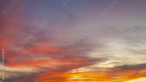 Sunset sky background with colourful golden yellow skies in the evening during the sun going down, Amazing skyline with orange purple fire clouds, Nature background.