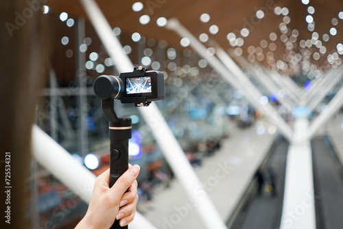 Asian lady holding the action camera with gimbal and taking video. photo