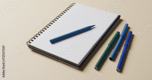 Wallpaper Mural Close up of notebook with blue markers on beige background, in slow motion Torontodigital.ca