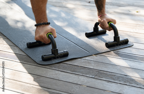 Push-up from the floor on hands close-up. Chest workouts and upper body training with push-up bars, featuring different variations and angles to target specific muscle groups. photo