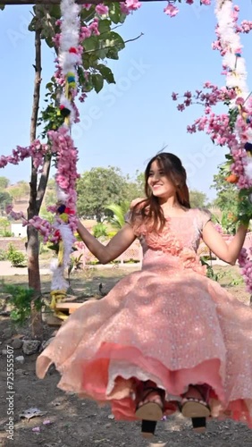woman on swing. Smile face. Flowers and beautiful dress. Happy woman. Lady in flowers swing 