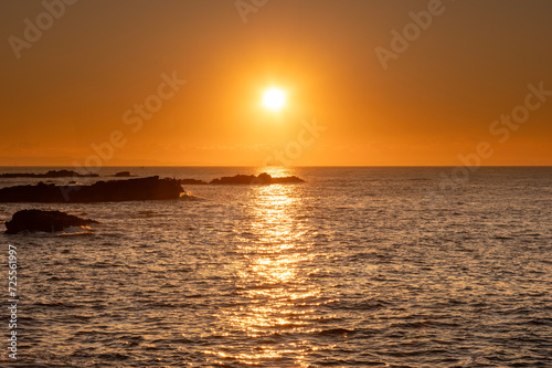 オレンジ色の朝日に染まる磯と海 © officeU1