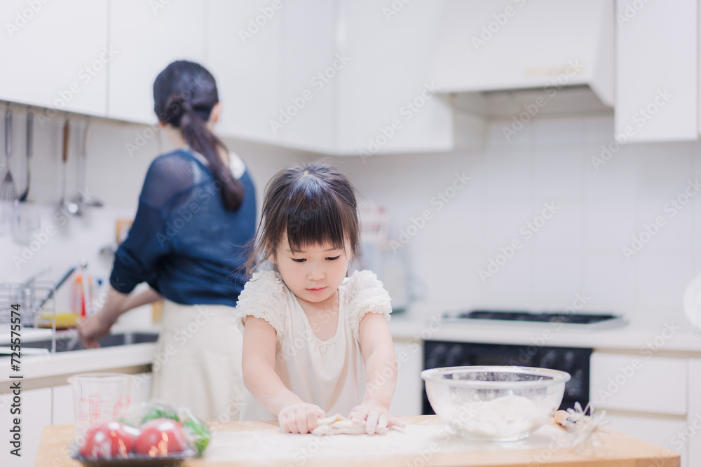 料理を手伝う女の子とお母さん