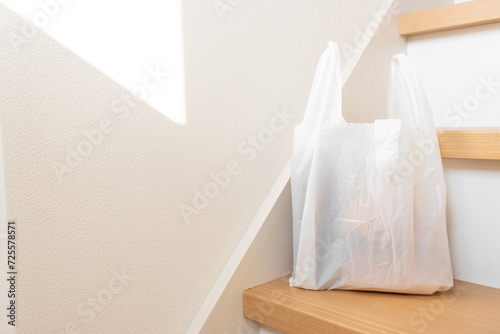 階段に置かれた食品の入ったレジ袋のイメージ photo