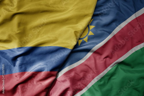 big waving national colorful flag of namibia and national flag of colombia .