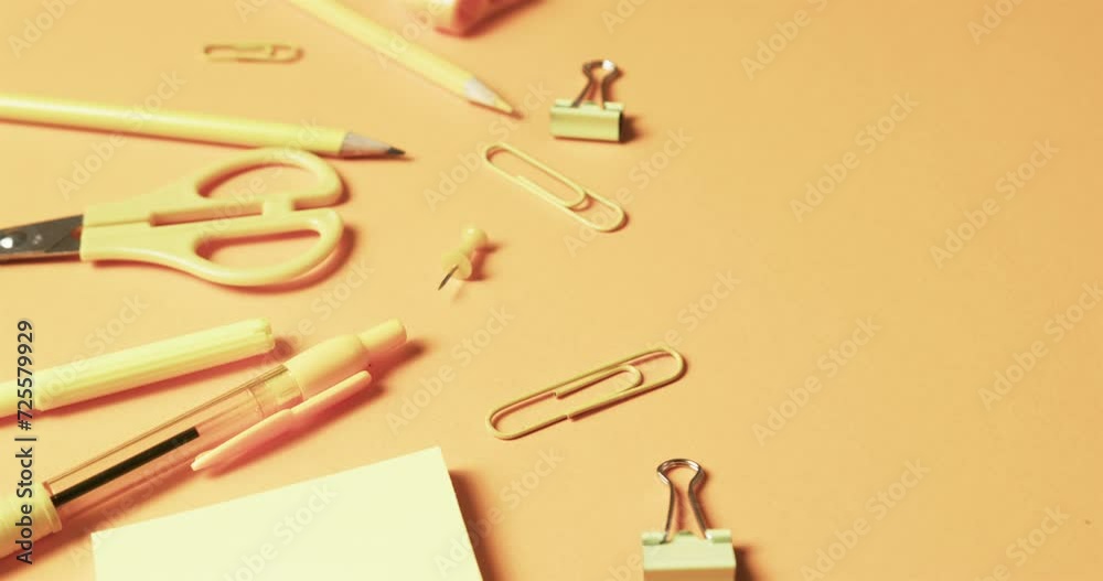 Close up of school stationery on orange background, in slow motion Close up of school stationery on orange background, in slow motion