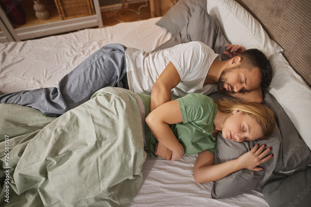 Couple sleeping embraced in bed