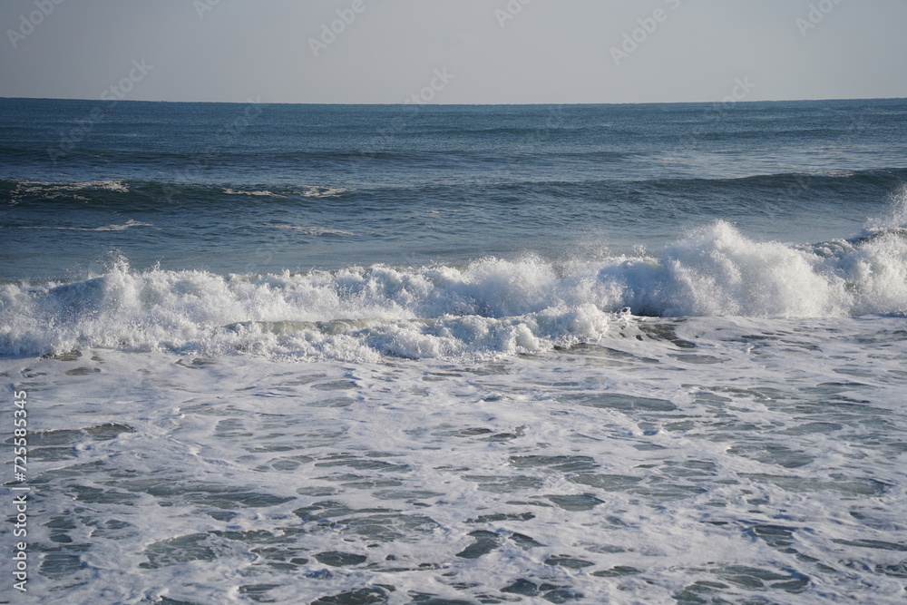 Winter sea waves splashing with white foam