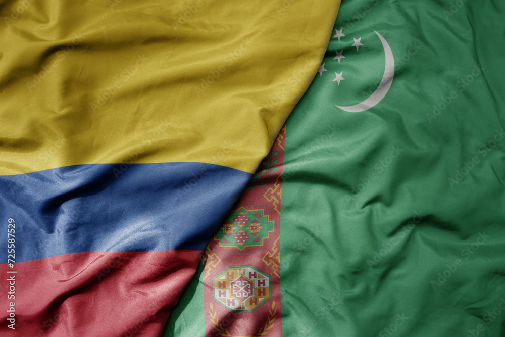 big waving national colorful flag of turkmenistan and national flag of colombia .