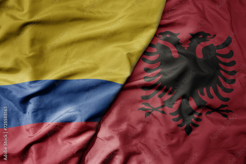 big waving national colorful flag of albania and national flag of colombia .