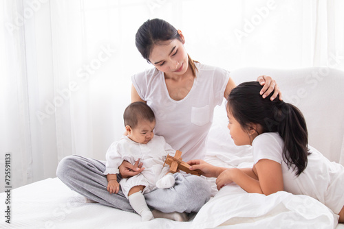 Selective focus young Asian beautiful mother hold newborn baby 0-1 month in her arms with love, gently, infant happy sleeping mom looking infant , newborn baby feeling secure while sleeping in mom arm