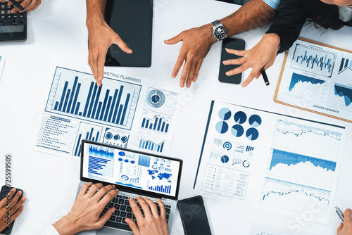 Top view analyst team utilizing BI Fintech to analyze financial data at table in meeting room. Analytic BI dashboard power on paper for business insight and strategic marketing planning. Prudent photo