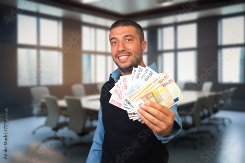 oung Caucasian Man in the Conference Room with Euro in Hand