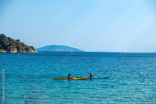Two canoe kayak with oar in vast blue calm Greek sea. Summer holiday fun and healthy sport activity