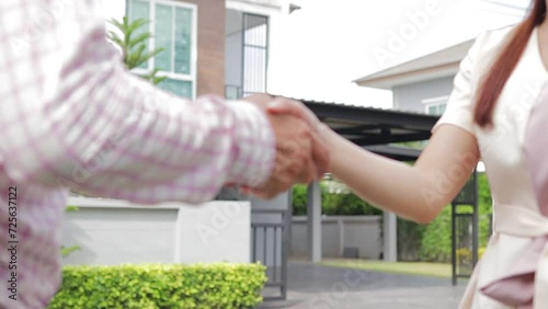 The contractor shakes hands with the homeowner, thanking them and expressing congratulations on the new home. Construction industry concepts. New home  photo