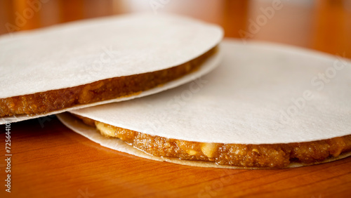Close view of two Alajú cakes, a Castilian sweet of Arab origin, traditional in the regions of Cuenca and Rincón de Ademuz in Spain, displayed on a wooden table