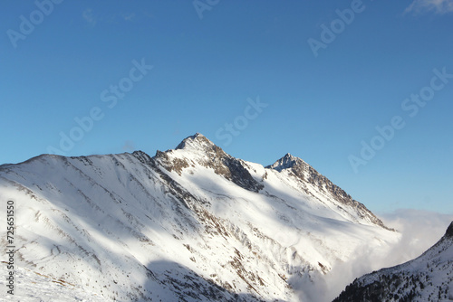 Sunny mountains peaks in winter Alps.
