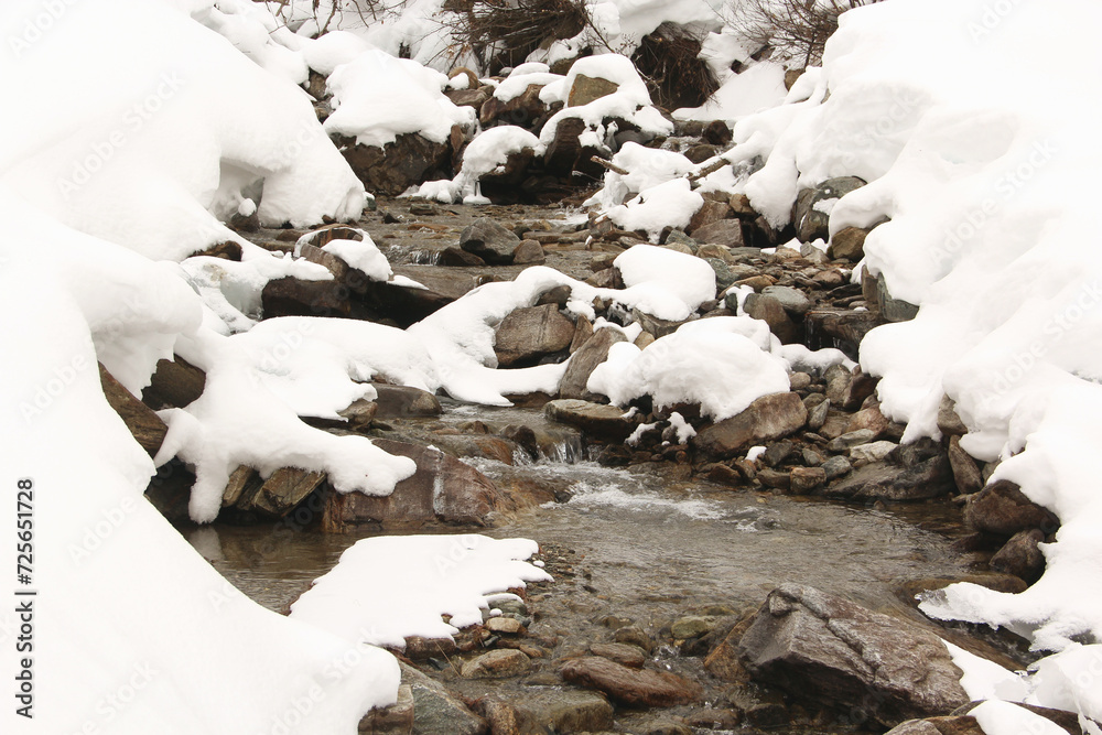 Melting white snow in mountain creek. Cold water.