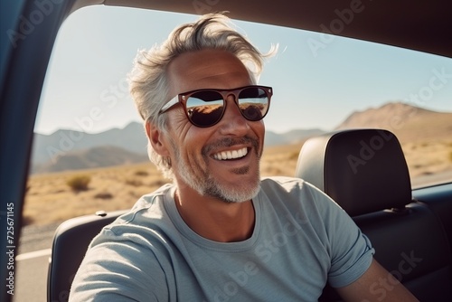 Portrait of a smiling mature man driving a car in the desert