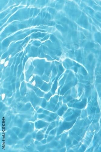 Water surface. Bluewater waves on the surface ripples blurred. Defocus blurred transparent blue colored clear calm water surface texture with splash and bubbles. Water waves with shining pattern.