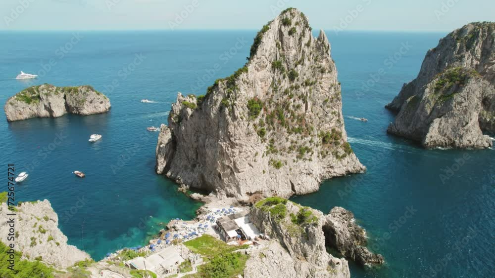 Capri's Dramatic Seascapes and Faraglioni Rocks View. Aerial view of Mediterranean sea in Summer Italy. Iconic Stacks Stella, Mezzo, Fuori. Capri's Dramatic Seascapes and Faraglioni Rocks View. Aerial view of Mediterranean sea in Summer Italy. Iconic Stacks Stella, Mezzo, Fuori.