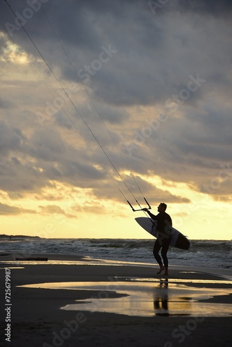 Kiteboarding. A man plays sports on the sea waves