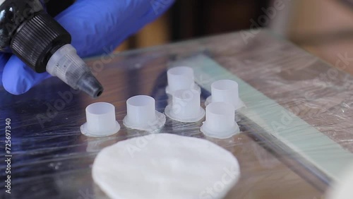 Tattoo artist in gloves prepares black pigment for the tattoo machine. Close up