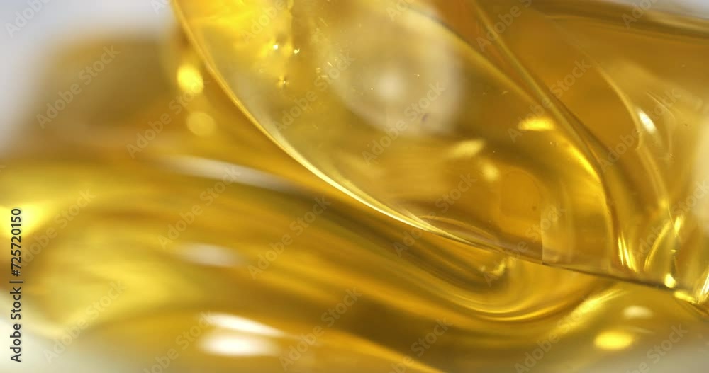 Super slow motion macro of bio organic golden sticky liquid honey is flowing and dripping at 1000 fps. Super slow motion macro of bio organic golden sticky liquid honey is flowing and dripping at 1000 fps.