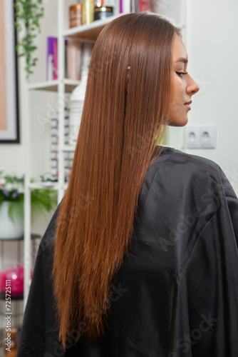 Portrait of a beautiful woman with long brown straight hair in a beauty salon.