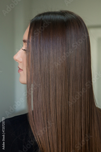 Portrait of a beautiful woman with long brown straight hair in a beauty salon.