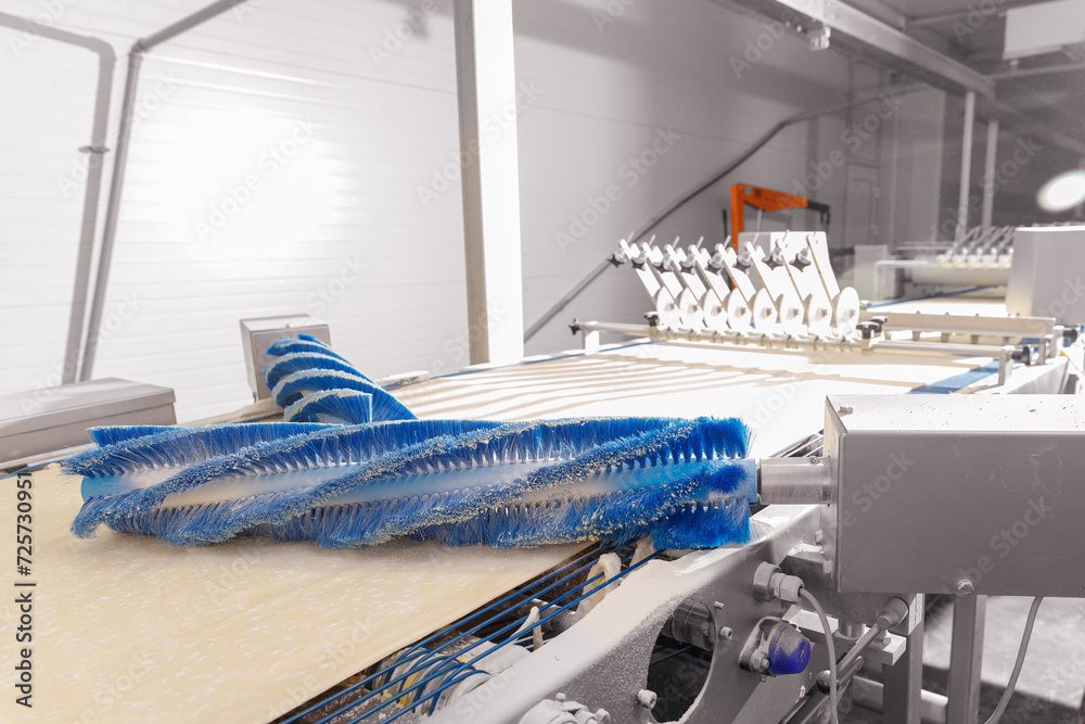 Mechanical dough robot making puff pastry for production French croissants on line conveyor