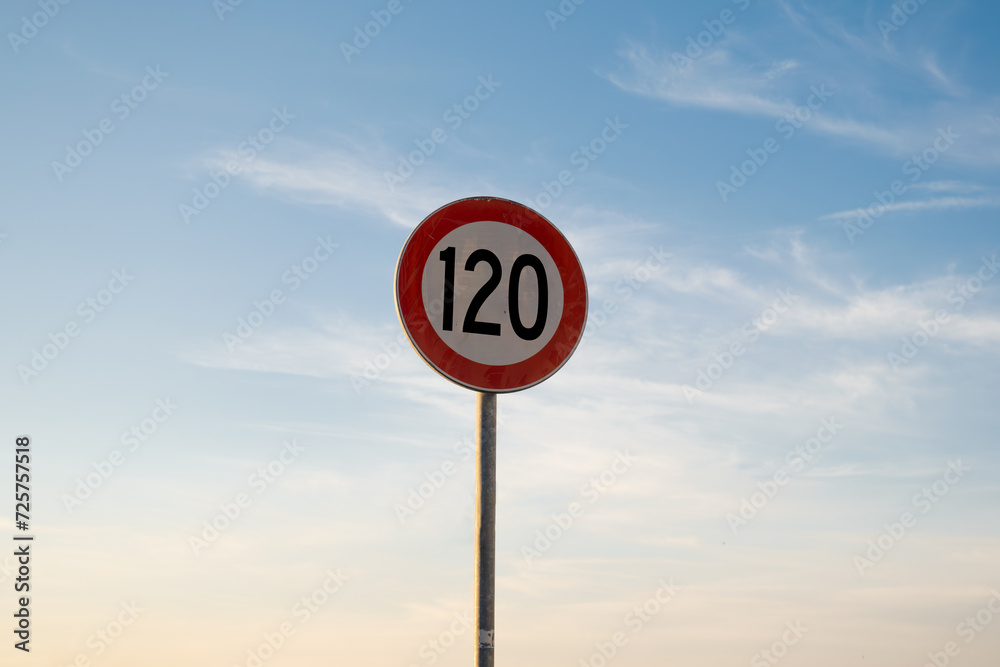 120 miles km maximum speed limit traffic sign isolated with sunset sky